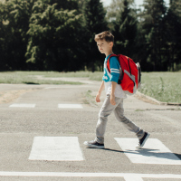 Boy at school crossing with backpack