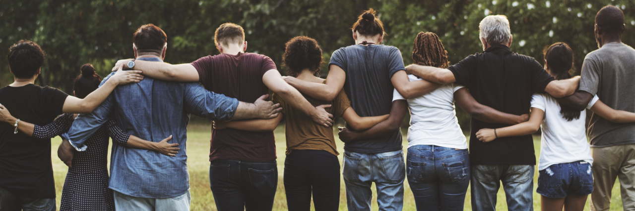 The Importance of Being in a Community of People Who Have Your Illness A group of friends huddled together, facing away from the camera.