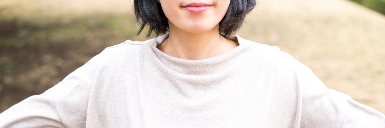 The Negative Phrase That Freed Me as I Redefine Success With POTS A woman standing outside with her arms stretched wide.