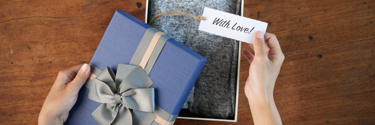 woman opening a gift with a card that says 'with love'