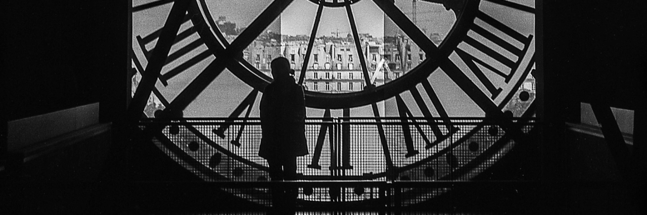 When Chronic Fatigue Syndrome Has No Beginning and No End A woman standing inside a tower, in front of a giant clock.