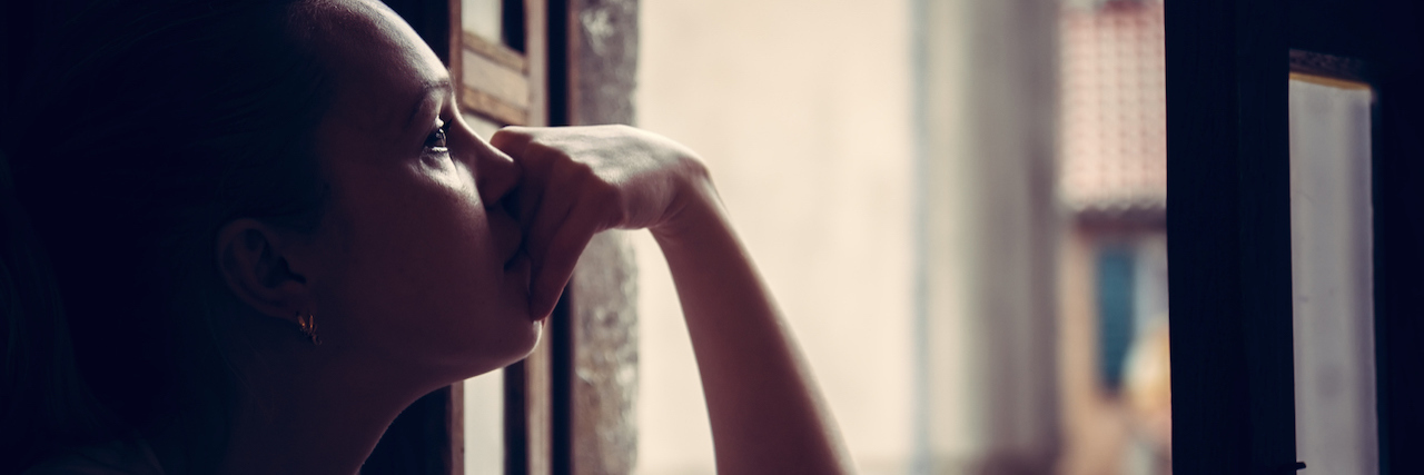 A Letter to My Emotionally Abusive Dad on Father's Day A woman looking out the window