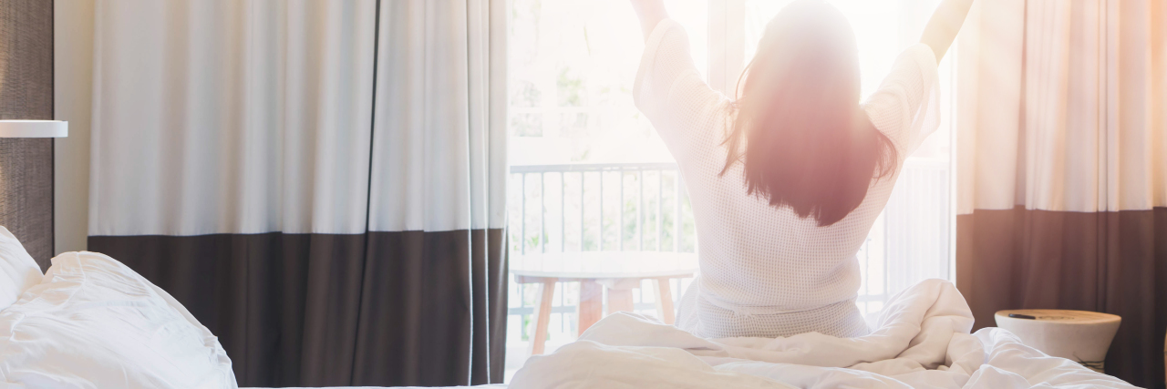 Managing Life With a Chronic, Rare Illness woman waking up in the morning, stretching arms