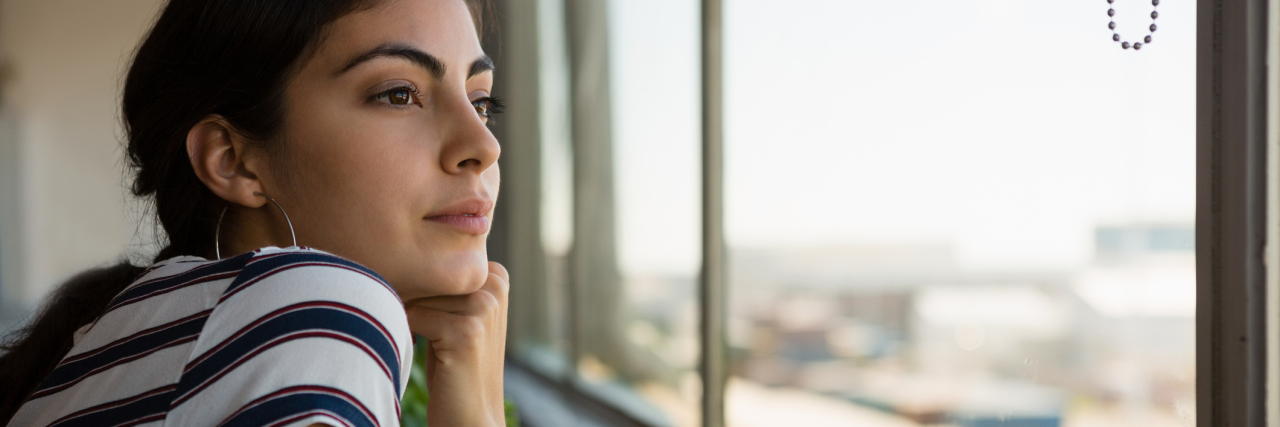 Having Expectations With Fibromyalgia woman leaning on a windowsill looking outside