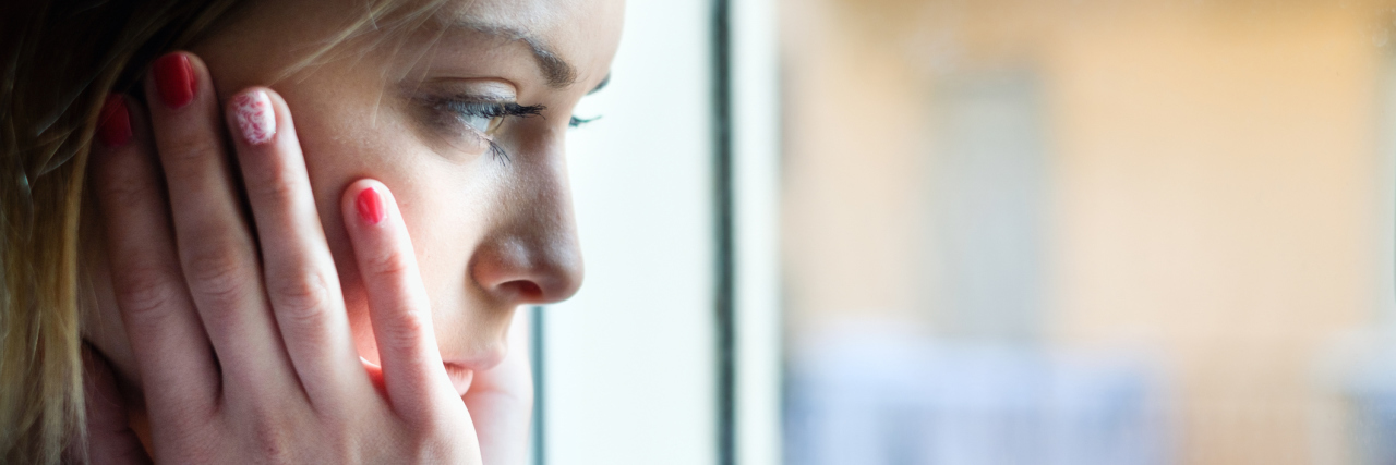 Not Fitting in With People Your Age Because of Chronic Illness woman looking out a window