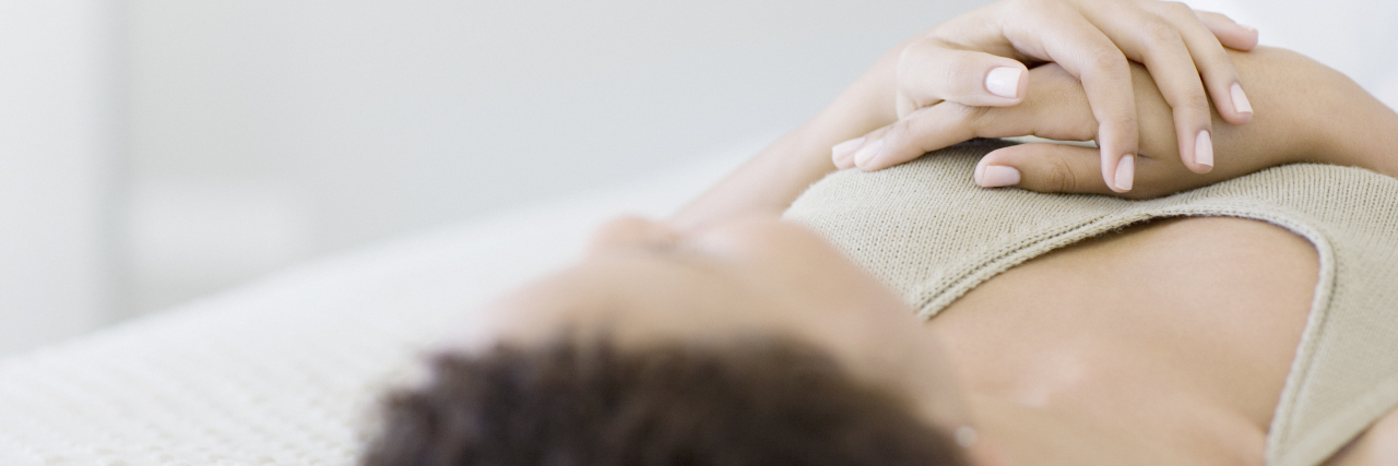 Living With Cervical Dystonia and Being Misdiagnosed Woman relaxing on bed