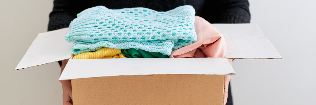 6 Ways You Can Give Back When You're Chronically Ill A person holding a box of clothes.