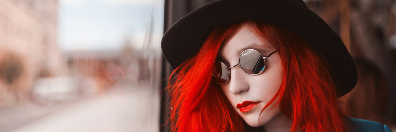 When Shame Is a 'Sub-Symptom' of Your Illness A woman with red hair look out a window.
