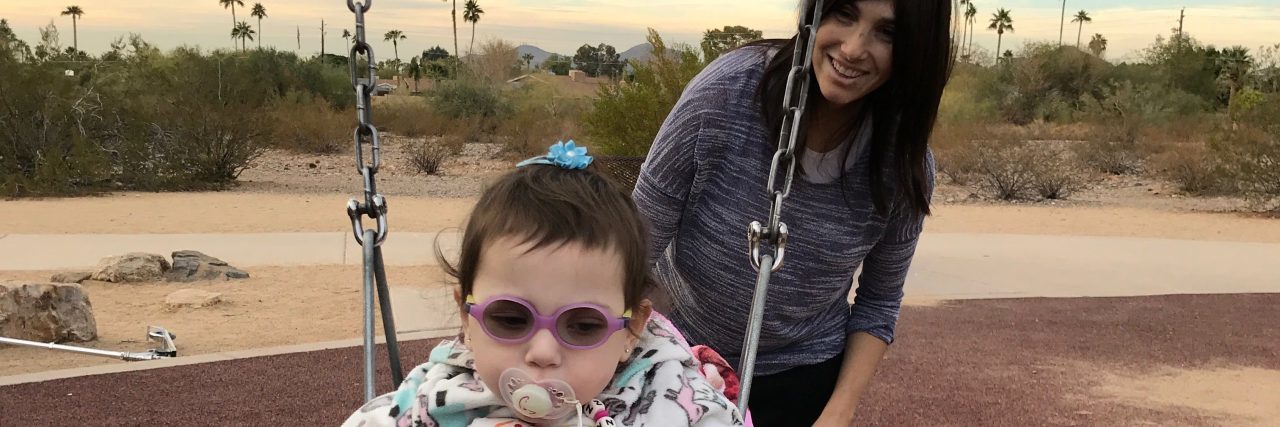 Letter to Parents of Children With Life-Limiting Conditions the author pushing her daughter in a swing