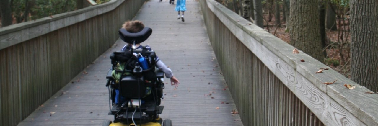 When Your Child Points or Stares at a Person Who Uses a Wheelchair Child in wheelchair crossing a bridge behind siblings