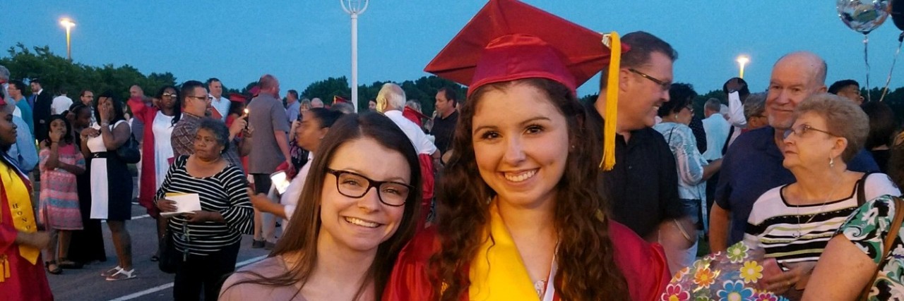 Why It's Such a Big Deal to Graduate High School When You Are Ill A picture of the writer wearing a red graduation gown, standing next to her friend.