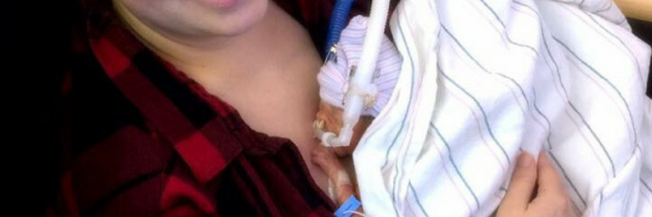 Mother holding preemie baby at hospital. Baby is so small laying on mom's chest