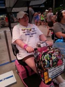 A picture of the writer in her mobility scooter at the theme park.
