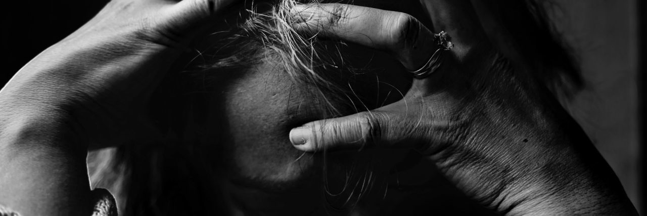 black and white photo of woman crying upset hands in hair