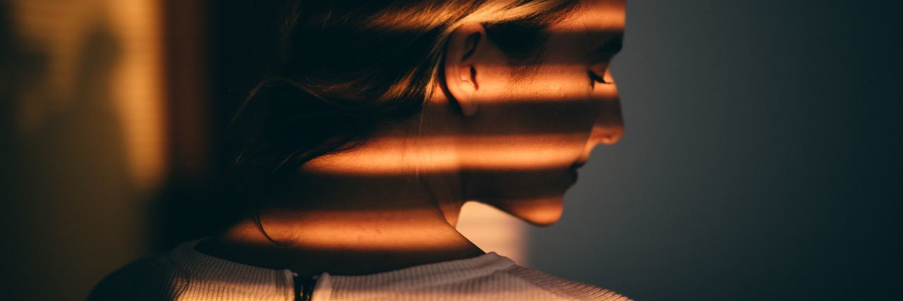 Struggling With Depression and Anxiety: The Reality of Chronic Pain woman with striped shadows falling across her face