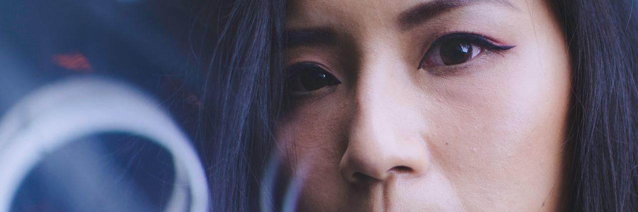 Having Postpartum OCD as an OCD Specialist asian woman looking serious at camera close up