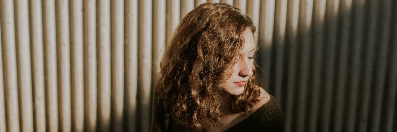 3 Ways to Get Through a Relapse in Eating Disorder Recovery woman sitting down with shadows across her