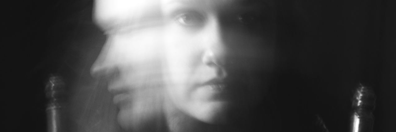 long exposure black and white photo of young woman turning head