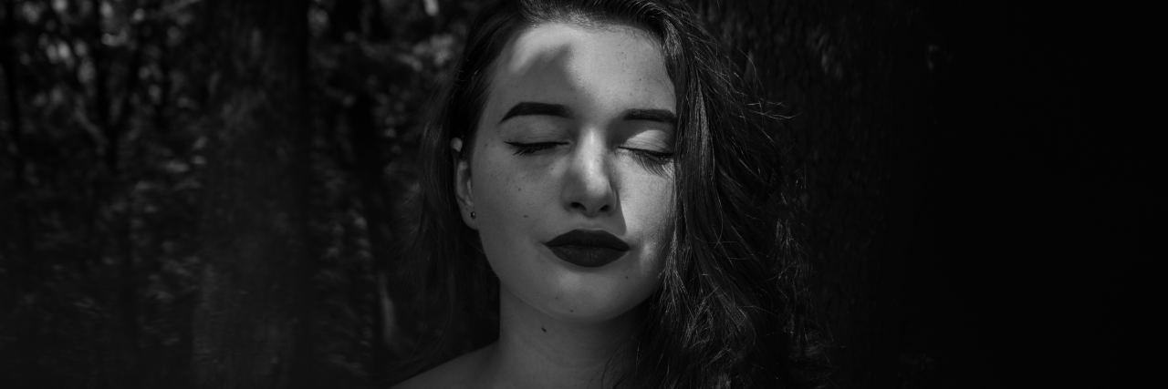 The Exhausting Subtleties of 'High-Functioning' Anxiety black and white photo of woman with plant shadows across her face