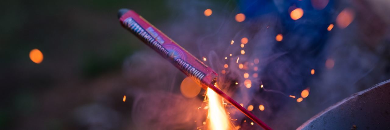 What You Need to Know About the Fourth of July, Fireworks and PTSD lit firework in bucket at night fourth of july