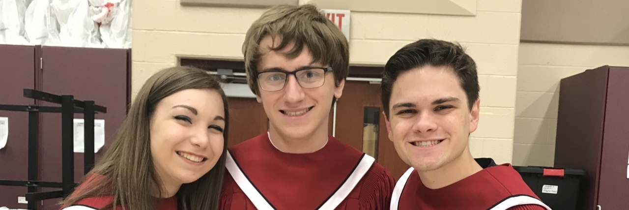 Ryan with his two friends, they are wearing their choir robes