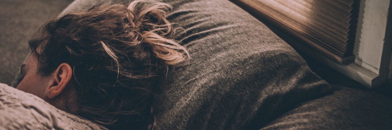 How to Cope With Suicidal Thoughts in Post-Traumatic Stress Disorder woman lying in bed facing away