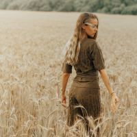 young blonde woman standing in wheat field