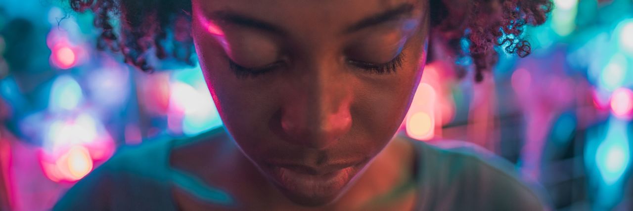 What Do You Do If Your Therapist Says Something Culturally Insensitive young woman with eyes closed and colored lights surrounding her