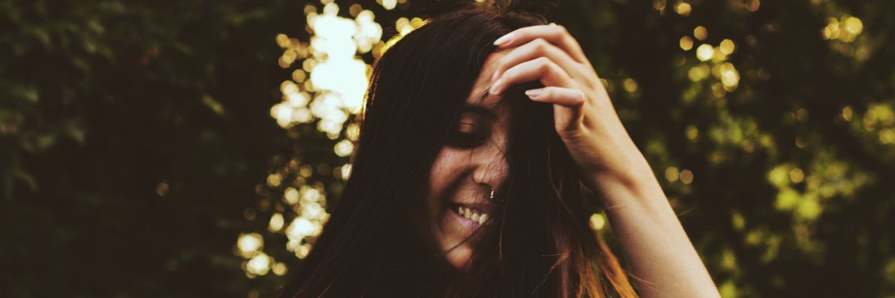 The One Thing That Brought Me Back to Life From My PTSD smiling woman whose hair is flying in the wind