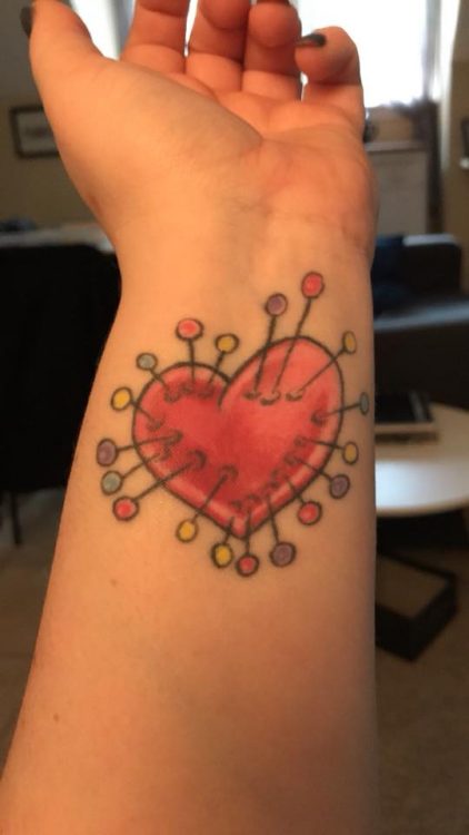 tattoo of heart with pins in it on wrist