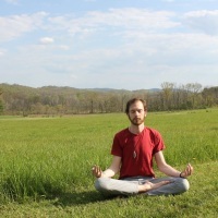 man meditating in field