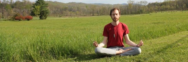 man meditating in field