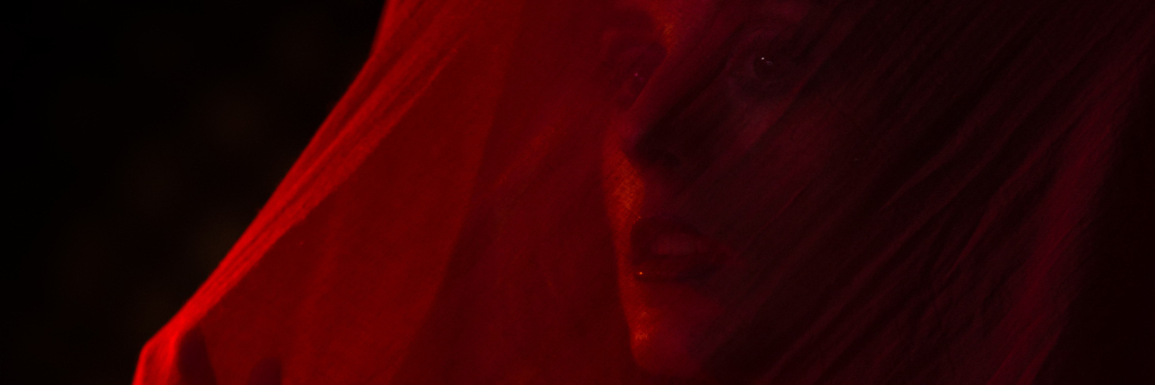 Why Having Migraine Is Like Wearing a Veil Girl posing with red cloth. Concept, abstraction