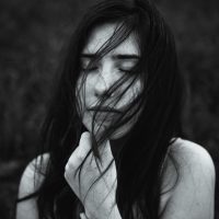 black and white photo of young woman holding hair and eyes closed