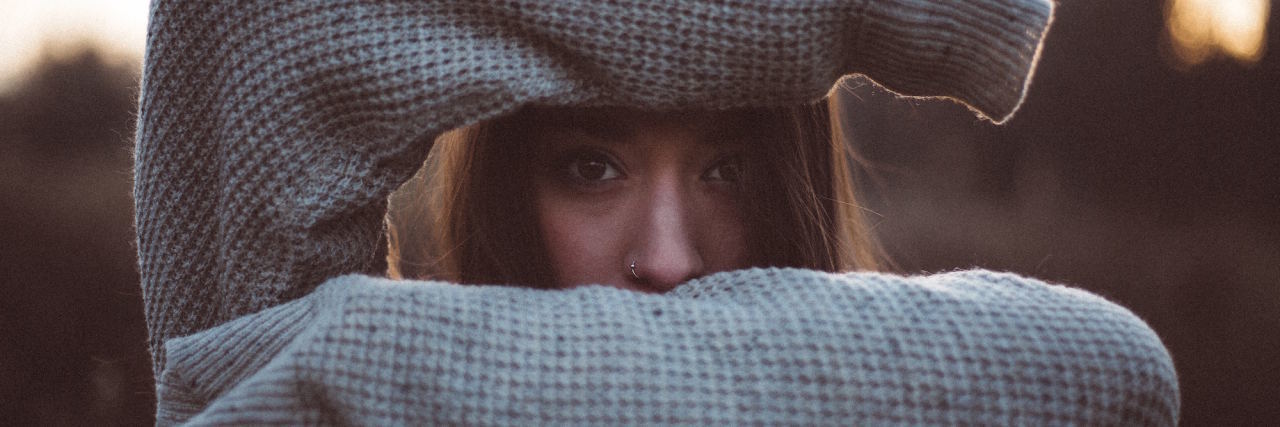 What It's Like to Be an Adult Struggling With the Impact of Childhood woman hiding behind arms