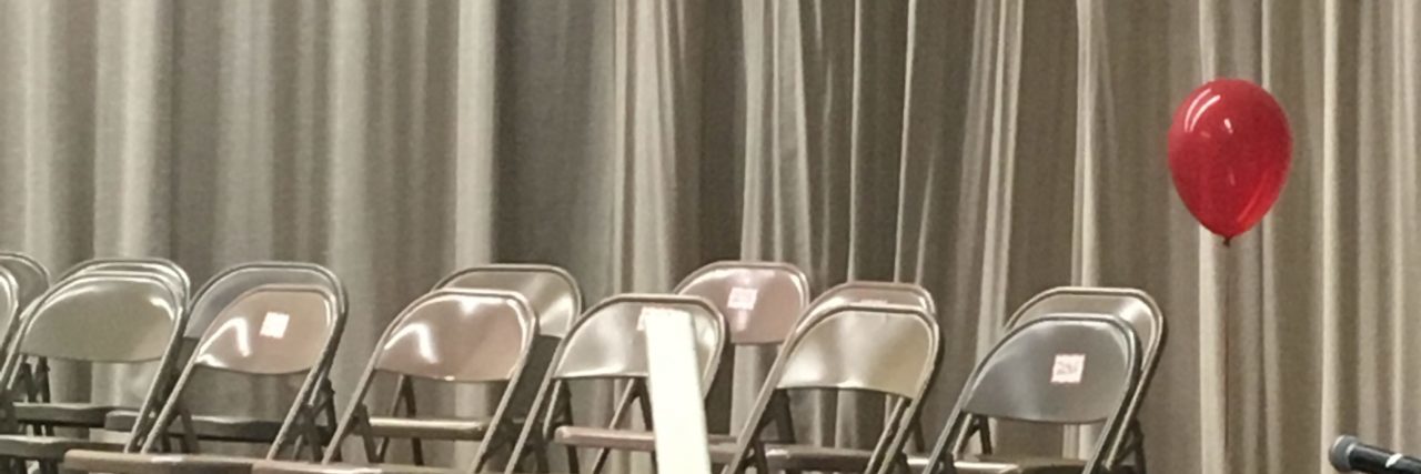 How a Single Red Balloon Was a Powerful Reminder of My Son Red balloon at end of row of empty metal chairs before a ceremony