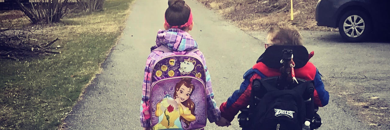 There Are Days My Son Says He Hates His Wheelchair, and That's OK Boy in wheelchair hand in hand with sister as they walk down the street