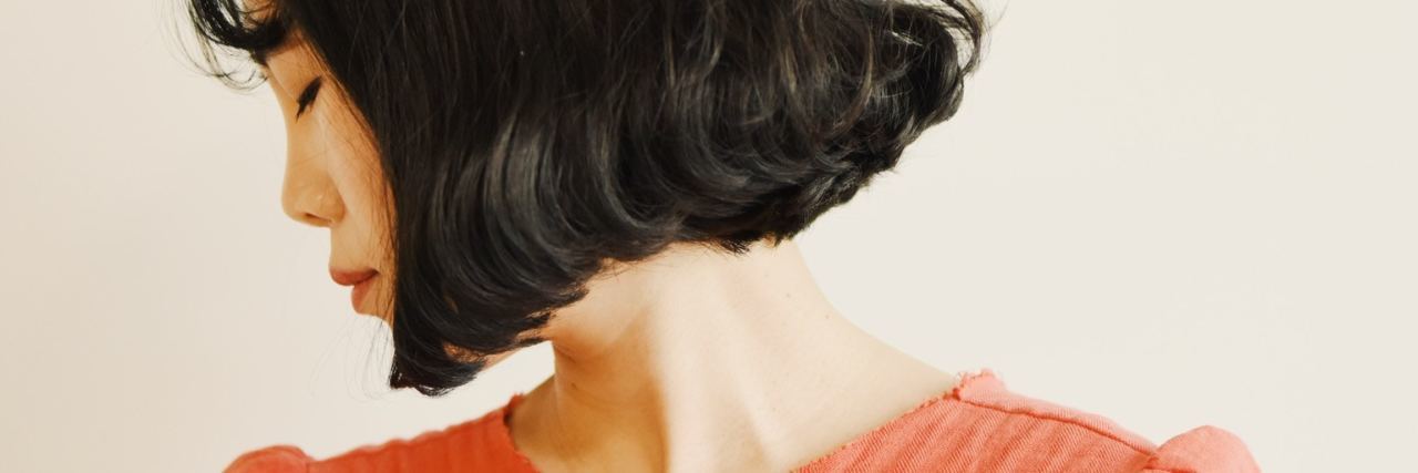 My Real Ambitions in Life as Someone With Depression and Anxiety young asian woman looking away wearing salmon color dress