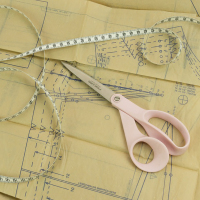 Clothing pattern, scissors and measuring tape.
