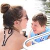 Sister and brother smiling looking at each other in a boat