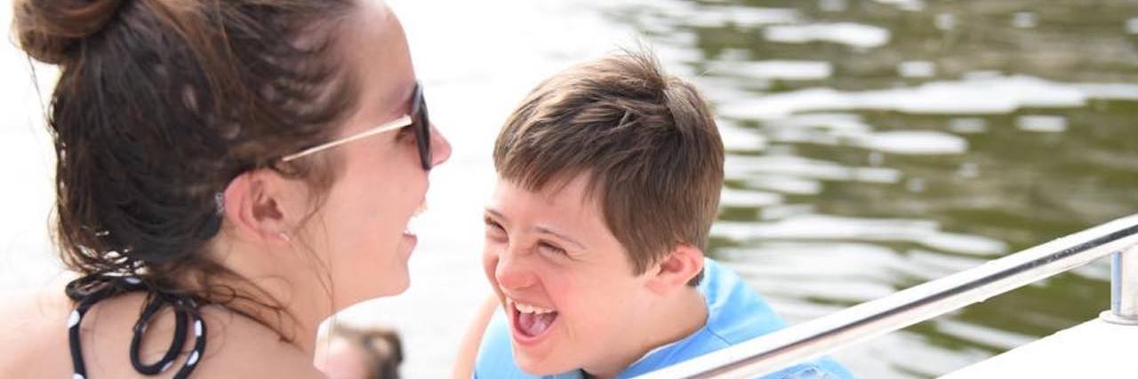 Sister and brother smiling looking at each other in a boat