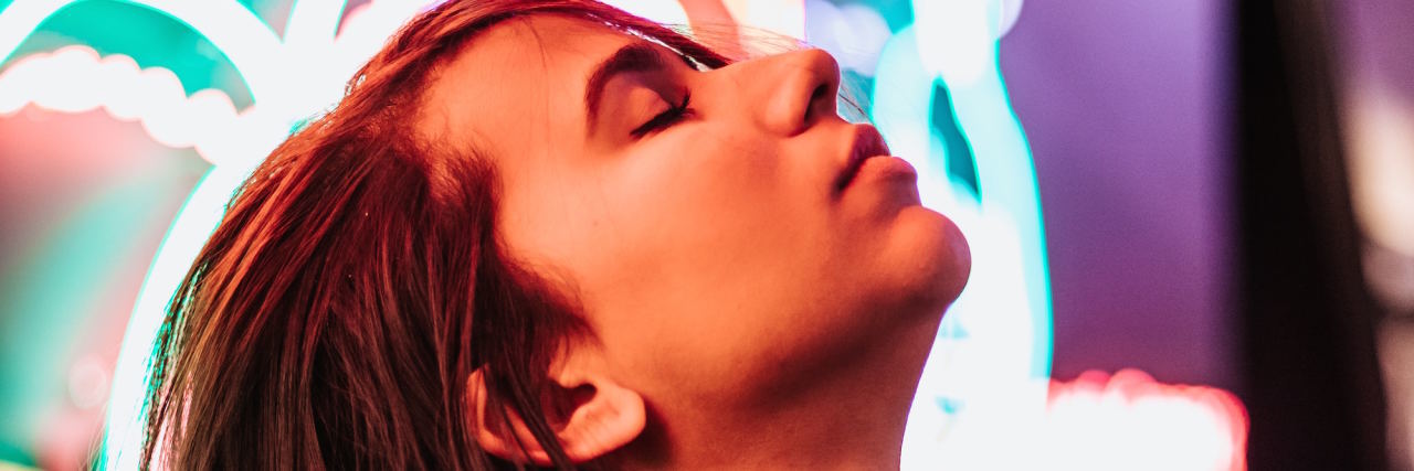 Why I Gave Myself Permission to Be a Victim of Trauma woman in front of neon light