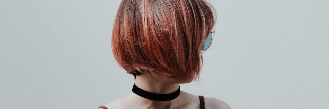 A woman with her head turned. She has short red hair. Text over her reads: 21 Uncomfortable Mental Health Symptoms We Don't Talk About