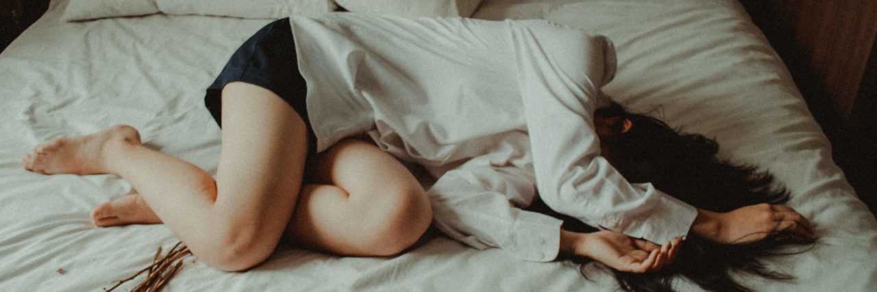 What ‘I Don’t Feel Well’ Really Means to a Person With Depression woman lying in bed unwell