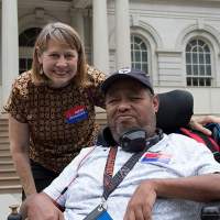 Disability Advocate Gilbert Plaza with HeartShare Executive Director Linda Tempel on the steps of New York City Hall.