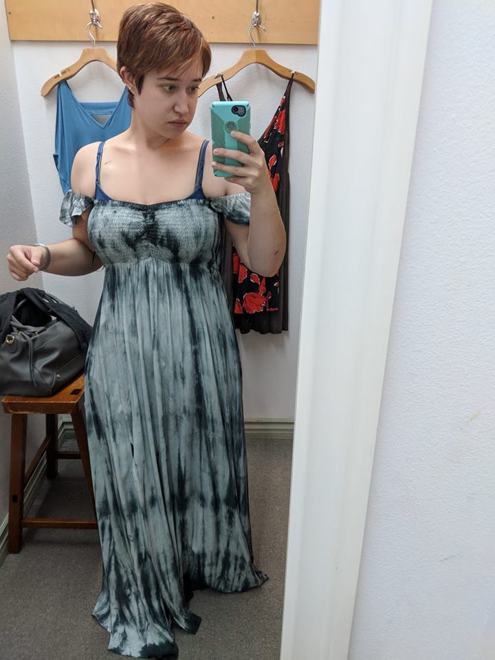 woman trying on a dress in a fitting room