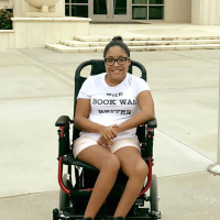 Tylia Flores sitting outdoors in a portable power wheelchair.