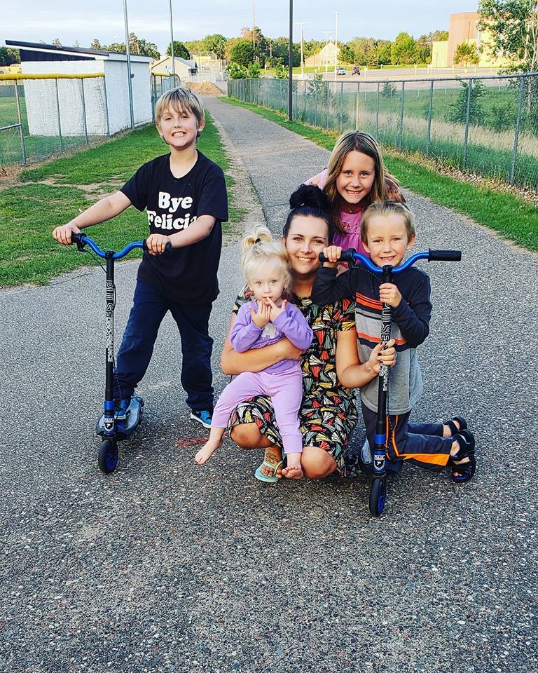 woman playing outside with young kids