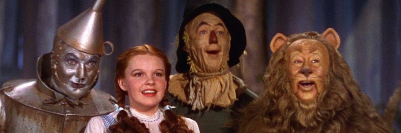 A picture from "The Wizard of Oz," showing the Cowardly Lion, Tin Man, Dorothy, and the Scarecrow.