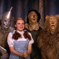 A picture from "The Wizard of Oz," showing the Cowardly Lion, Tin Man, Dorothy, and the Scarecrow.